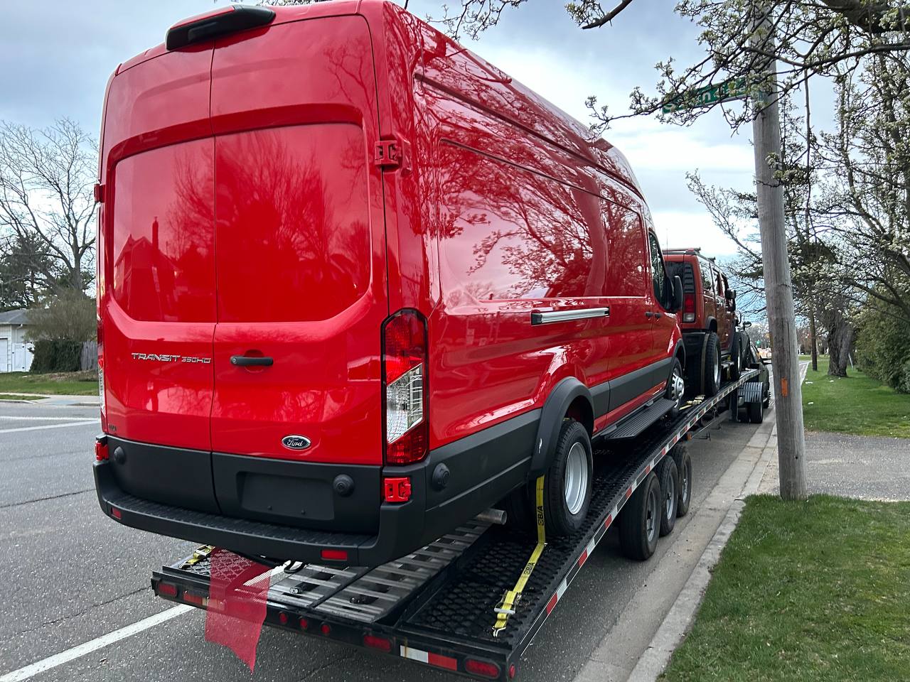 VS Performance LLC loading red Ford Transit van onto car hauler trailer