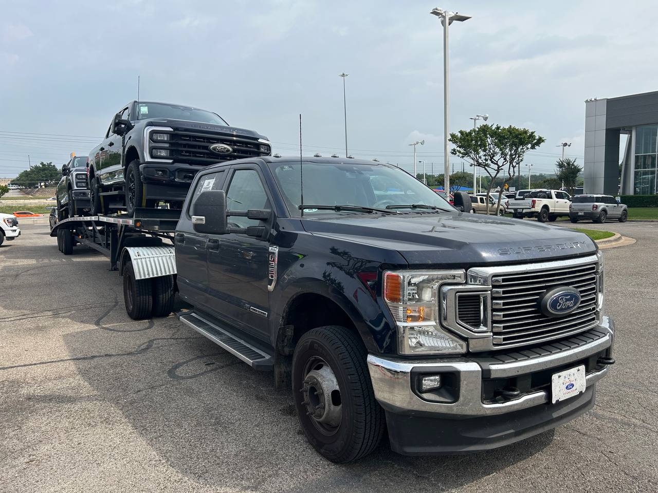 VS Performance LLC Ford Super Duty truck with car hauler trailer at dealership location