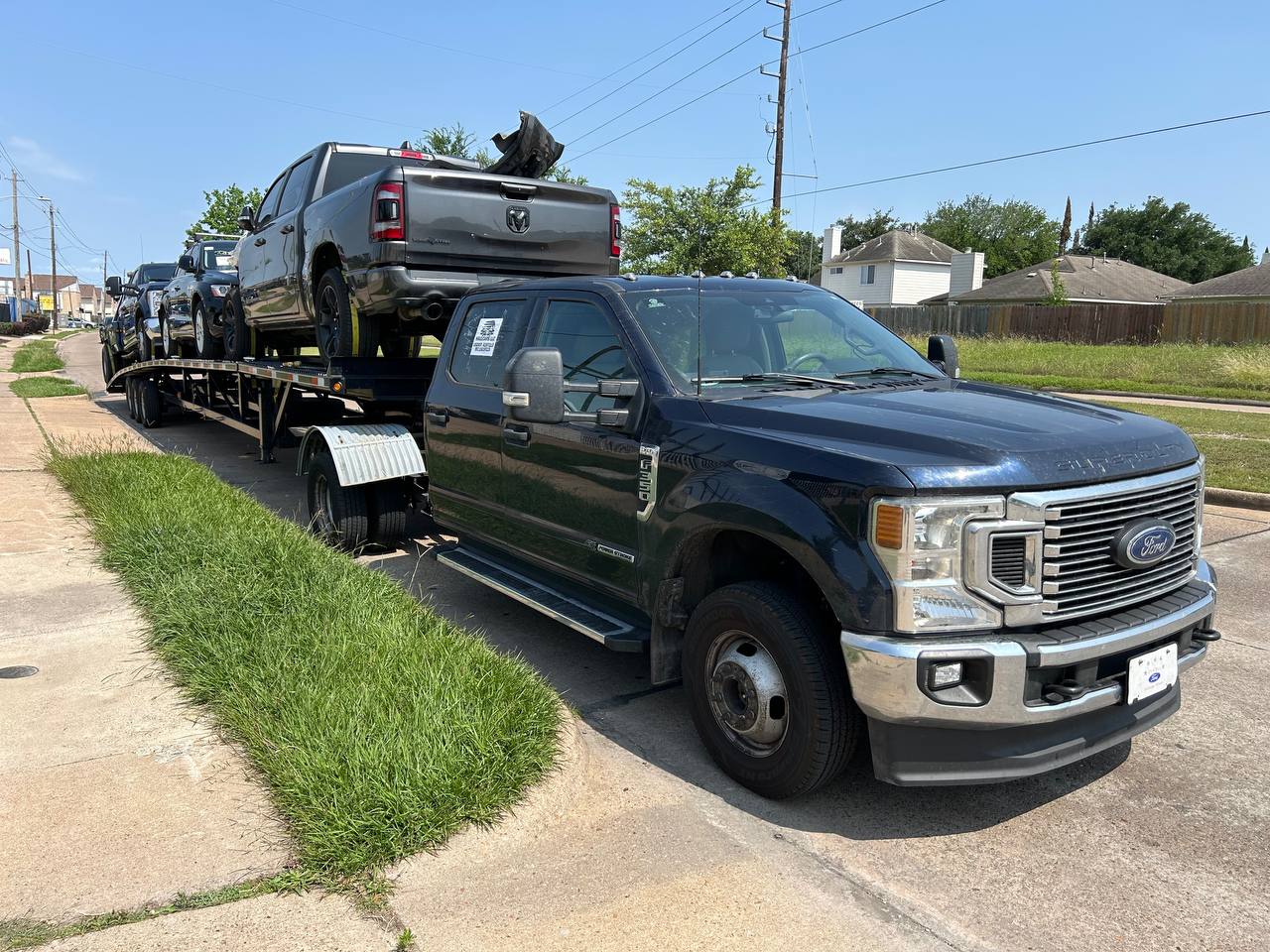 VS Performance Ford Super Duty truck with car hauler trailer loaded with vehicles in residential area
